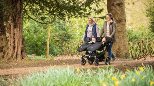 Two woman walking with pushchair in the Albana walk at Ickworth in spring